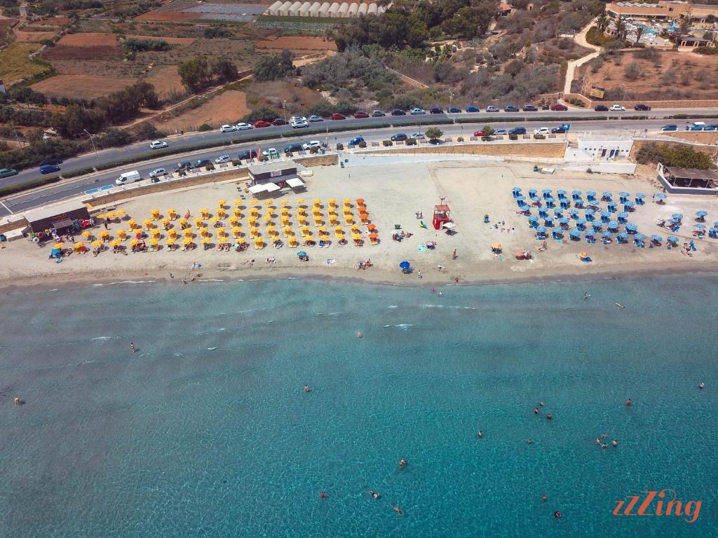 an aerial view of a beach with umbrellas and the water at Seafront Penthouse w unobstructed Sea Views in Mellieħa