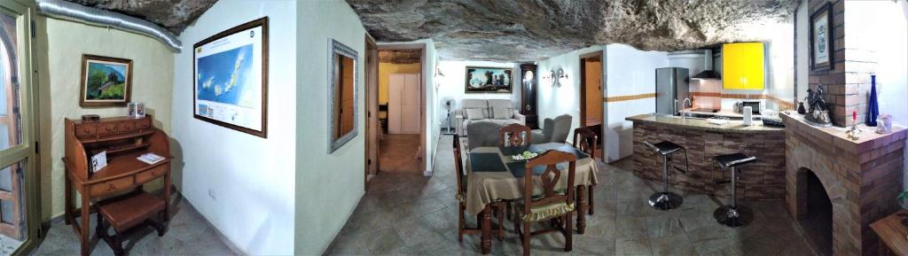 Habitación con comedor y cocina con mesa. en Cueva Sasha, en San Miguel de Abona