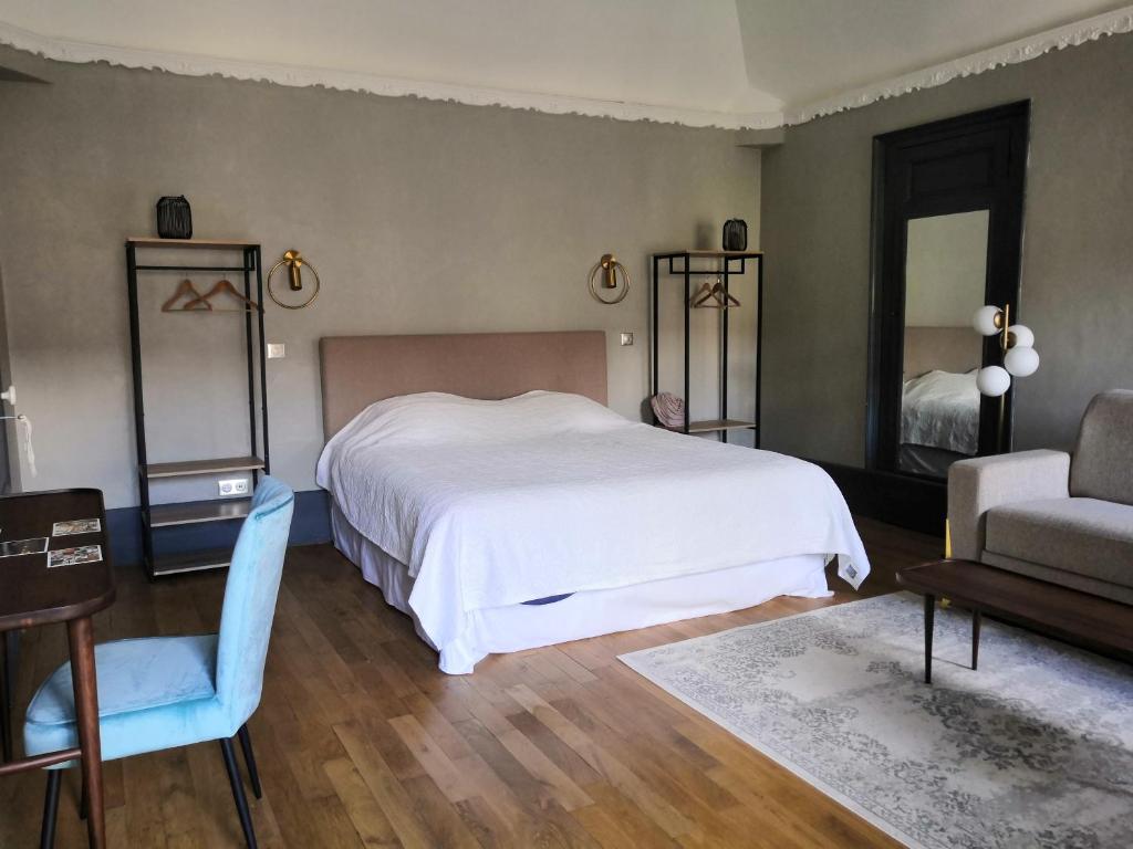 a bedroom with a bed and a chair and a couch at Clos Terre-lune in Nuits-Saint-Georges