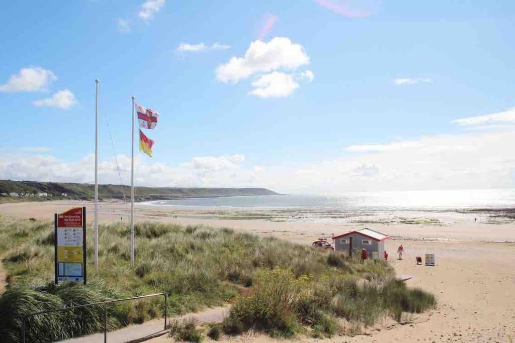 a beach with a sign and a flag on it at Cosy coastal home - 5 mins walk from the beach in Horton