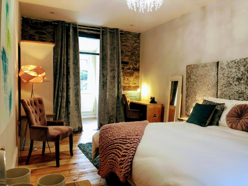 una camera con letto, sedia e scrivania di Cambrian House B & B a Carno