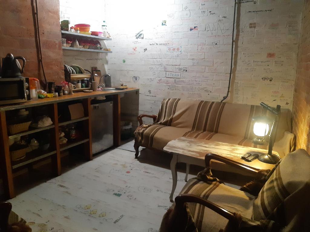 Hostel v Dnepropetrovske Grunge في دنيبروبيتروفسك: غرفة معيشة مع أريكة وطاولة