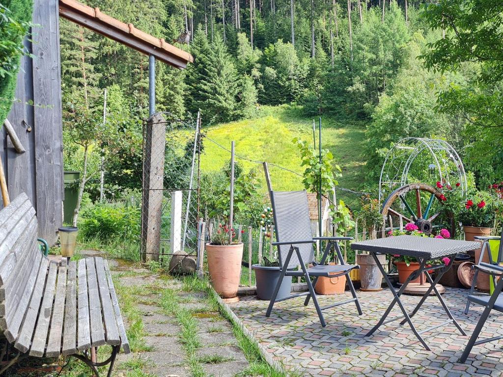 een patio met een tafel en stoelen en een bank bij Ferienwohnung am Wald in Baiersbronn