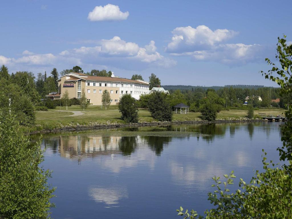 duży budynek obok dużego zbiornika wodnego w obiekcie Scandic Bollnäs w mieście Bollnäs