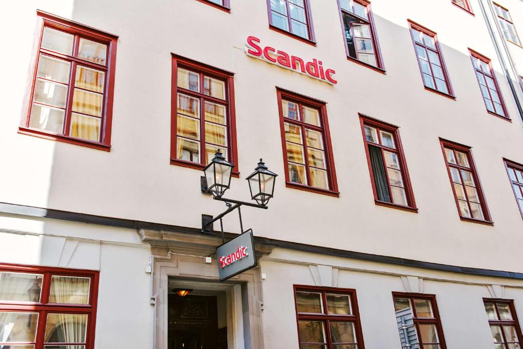 un edificio blanco con un cartel. en Scandic Gamla Stan, en Estocolmo
