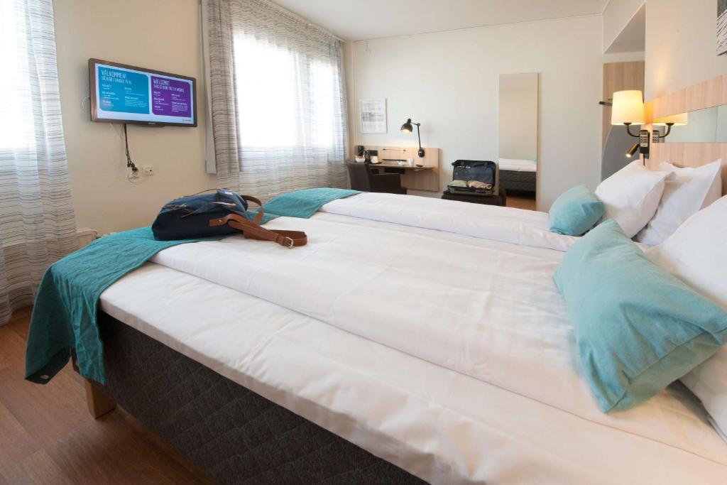 een groot wit bed met een zak erop bij Scandic Sundsvall City in Sundsvall