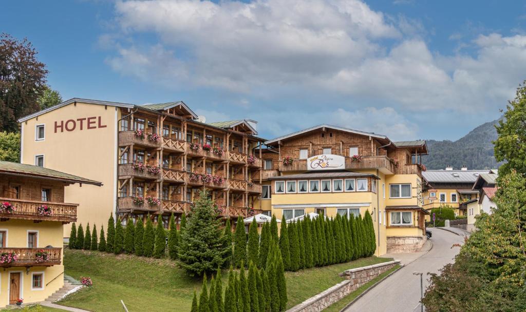 un hotel en las montañas con una carretera delante en Hotel AlpinaRos en Berchtesgaden