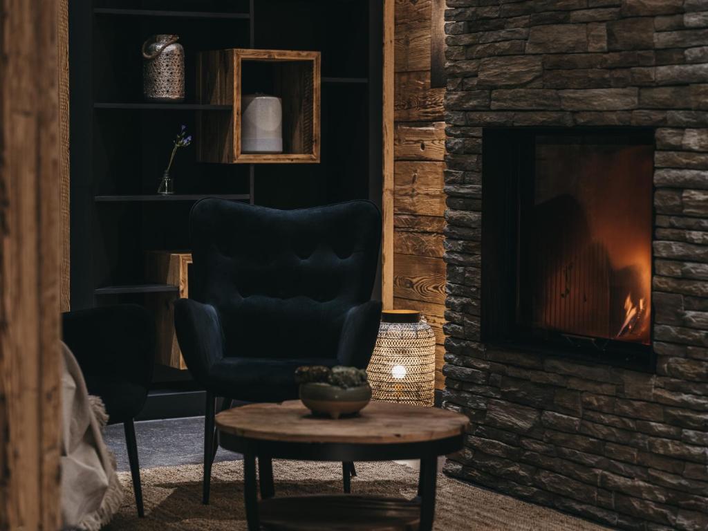 a living room with a chair and a fireplace at VAYA Sölden inklusive Summer Card in Sölden