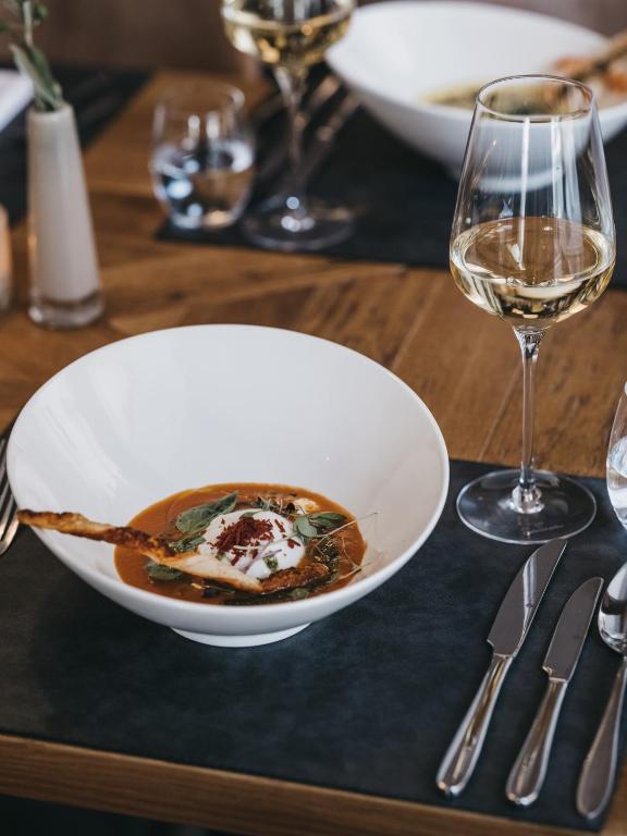 a plate of food on a table with a glass of wine at VAYA Sölden inklusive Summer Card in Sölden