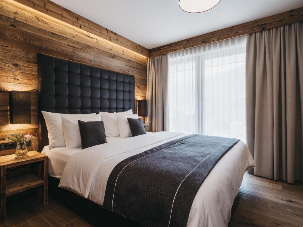 a bedroom with a large bed and a large window at VAYA Sölden inklusive Summer Card in Sölden