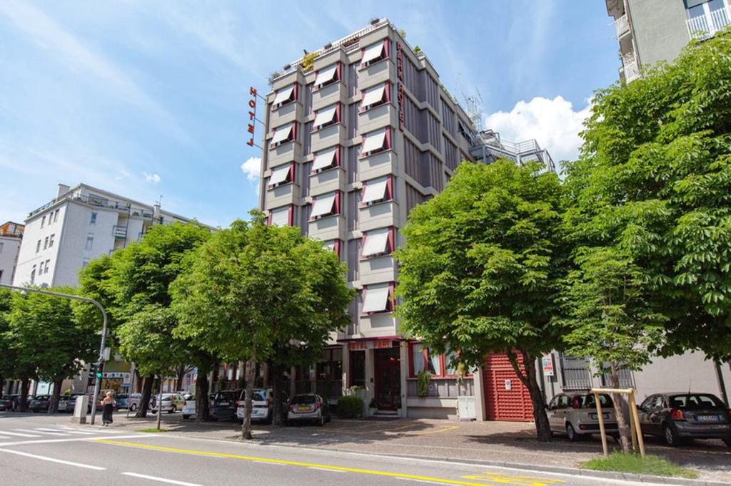 un edificio alto en una calle de la ciudad con árboles en Park Hotel Meublé en Como