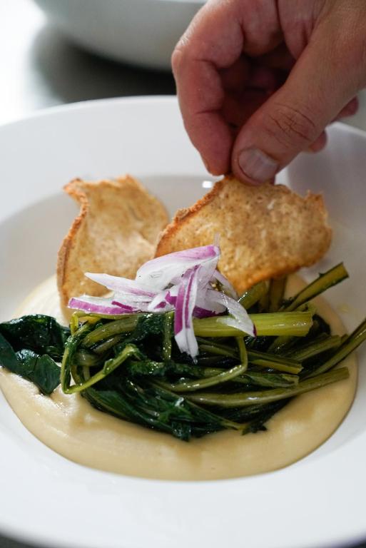 a person holding a piece of bread over a plate of food at Masseria Borgo Santuri in Ostuni
