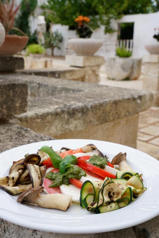 a white plate of vegetables on a table at Masseria Borgo Santuri in Ostuni