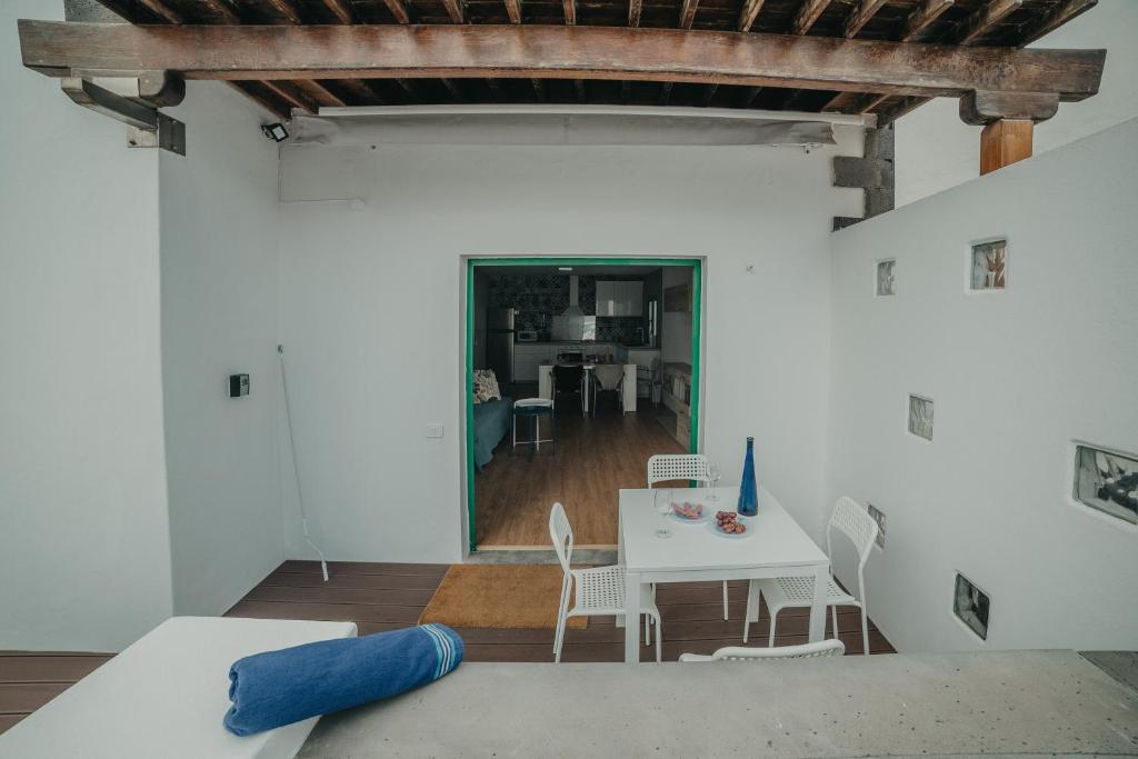 ein Wohnzimmer mit einem Tisch und Stühlen in der Unterkunft Rocker House, tranquilidad junto a las olas in La Santa