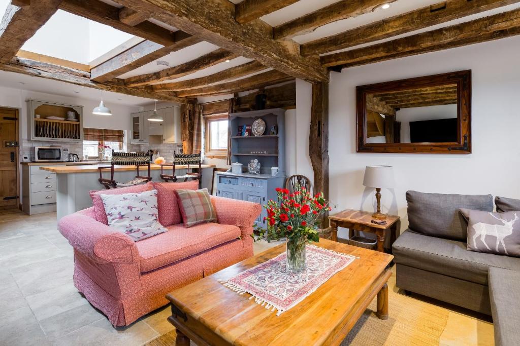 a living room with two chairs and a table at Old Barn Cottage in Horley