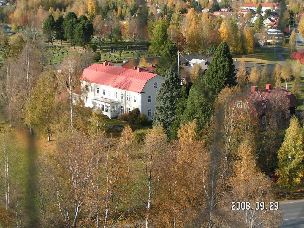 a large white house with a red roof on a hill at Stiftsgården Konferens & Hotell in Skellefteå