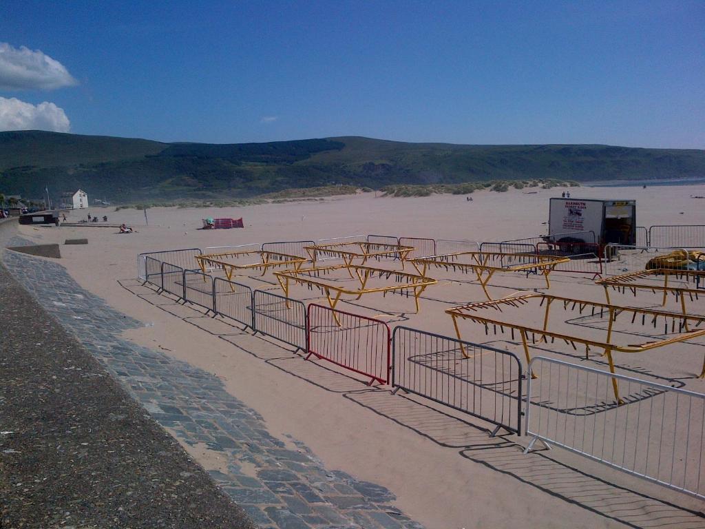 a beach with a bunch of bars on the sand at Tal Y Don Hotel in Barmouth
