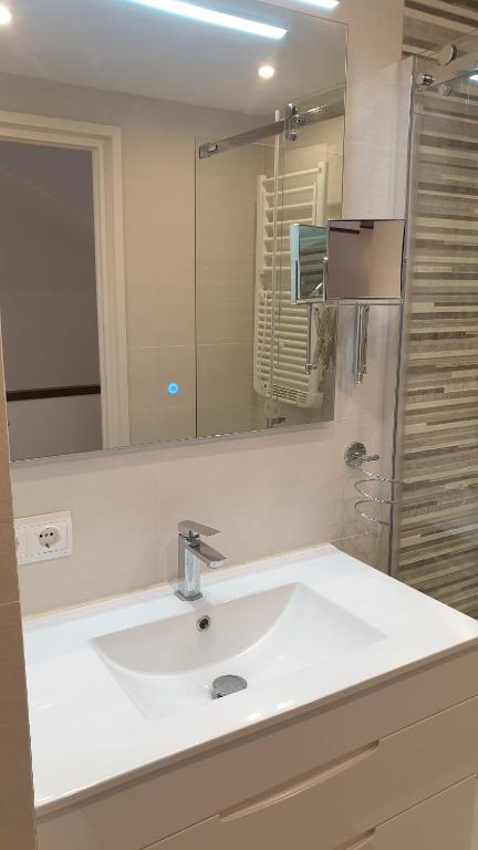 Un baño con un lavabo blanco y un espejo. en Mágico Apartamento Duplex Sota el Campanar, en Cadaqués