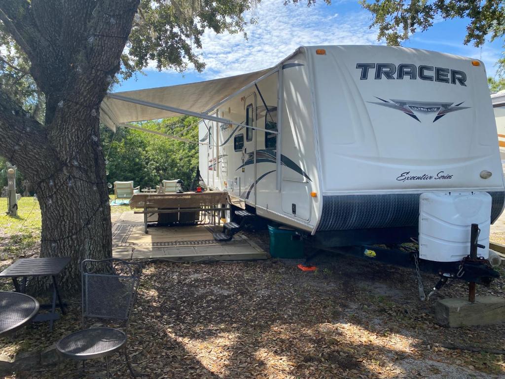 a white trailer parked next to a tree at Water Front Tracer RV by Glampers Camp in Port Charlotte