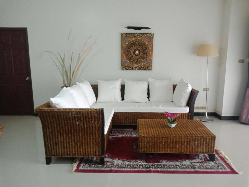 uma sala de estar com um sofá branco e duas mesas em Sandy Home 2 em Ban Thai Don (2)