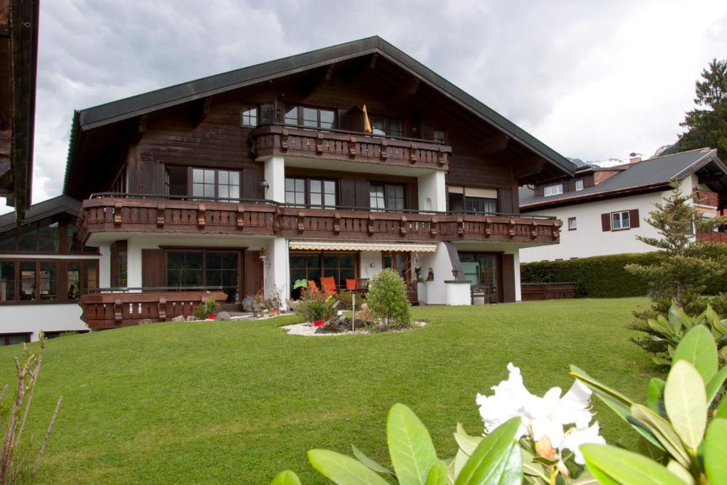 ein großes Haus mit großem Rasen davor in der Unterkunft Landhaus Kopp in Oberstdorf