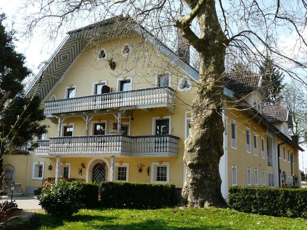 a large yellow house with a tree in front of it at Pension Gut Horn in Waging am See