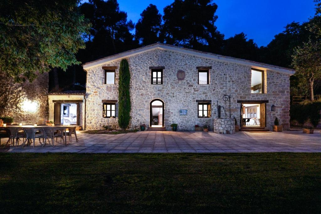 Casa de piedra con patio por la noche en Masia Ventanell Luxury villa near Barcelona en Llacuna