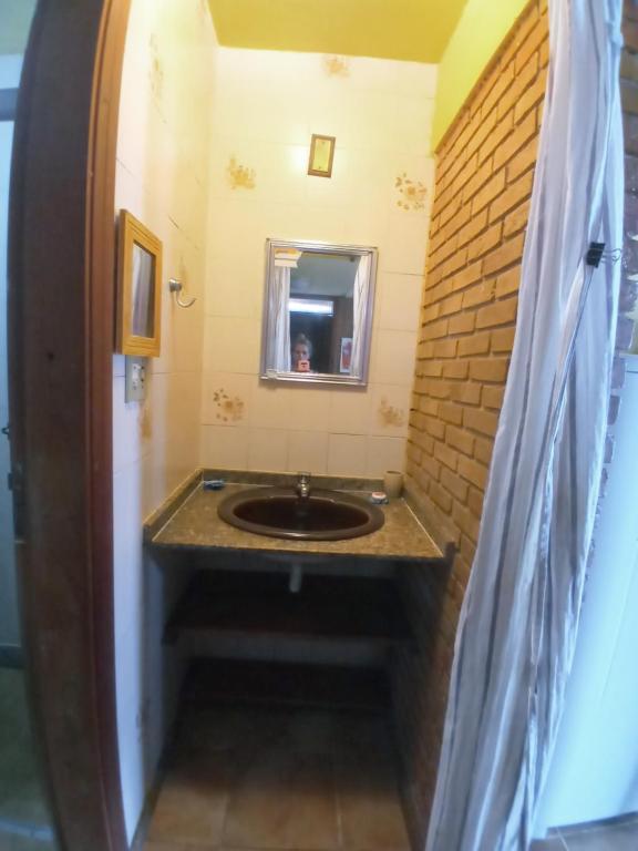 uma casa de banho com um lavatório e uma parede de tijolos em Chales praias de Ubatuba em Ubatuba