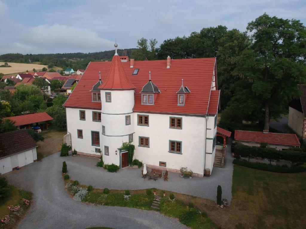 an aerial view of a large white house with a red roof at Schloß Roßdorf Ferienwohnungen & Camping in Roßdorf