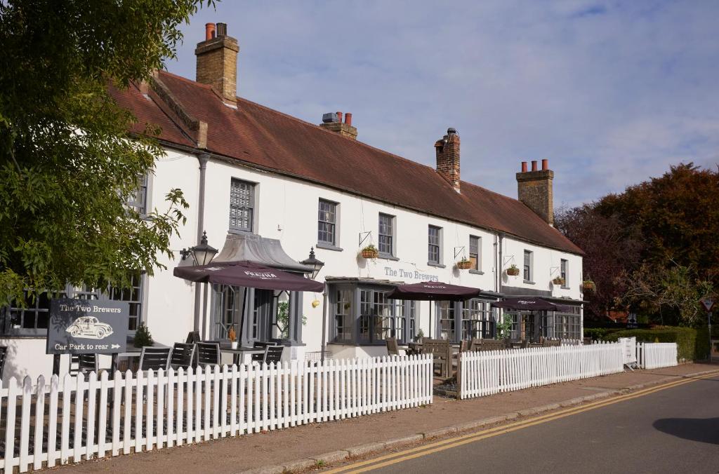 ein weißes Gebäude mit einem weißen Zaun davor in der Unterkunft Two Brewers by Chef & Brewer Collection in Kings Langley