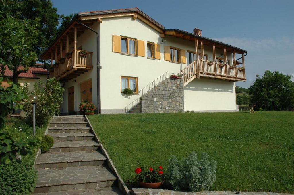 a large white house with a grass yard at Farm stay Šibav B&B in Dobrovo