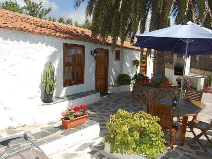 um pátio com uma mesa e um guarda-chuva em Casa rural las perez em Granadilla de Abona