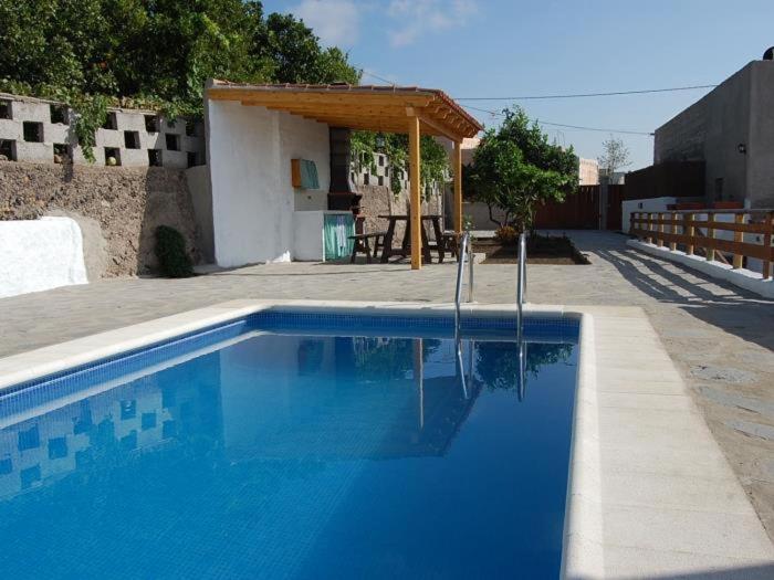 una piscina azul frente a una casa en Casa rural sofia, en Granadilla de Abona