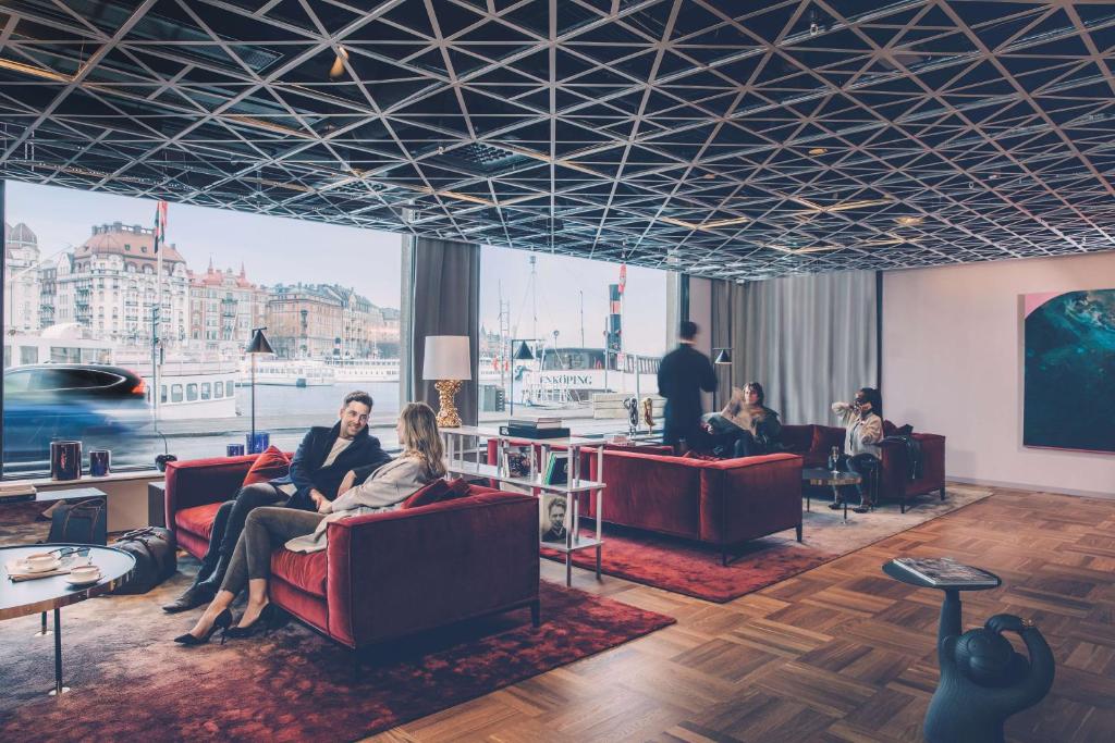 a group of people sitting in chairs in a room at Radisson Collection, Strand Hotel, Stockholm in Stockholm