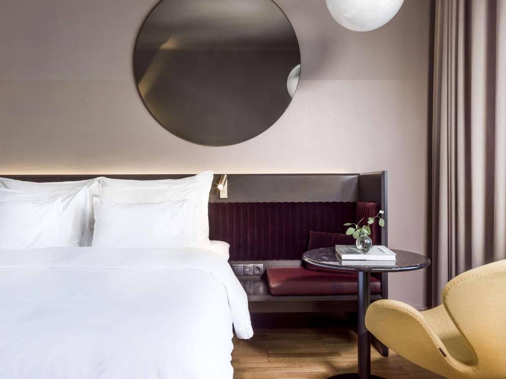 a bedroom with a bed and a table with a mirror at Radisson Collection, Strand Hotel, Stockholm in Stockholm
