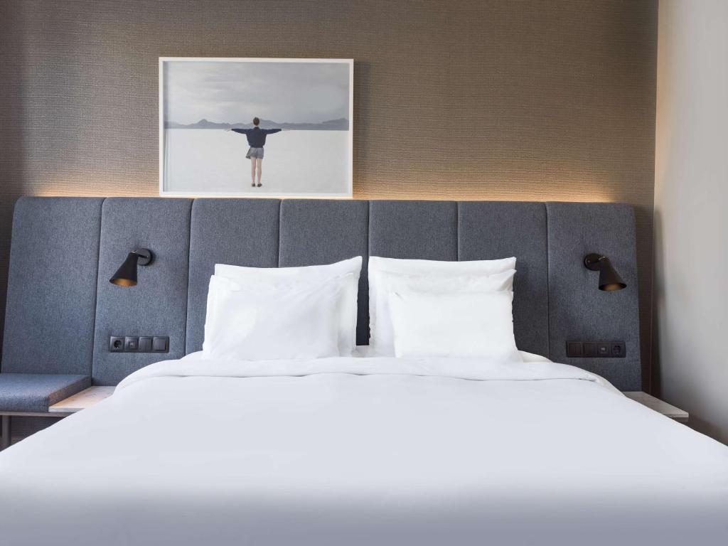 a bed in a hotel room with a picture on the wall at Radisson Collection, Strand Hotel, Stockholm in Stockholm