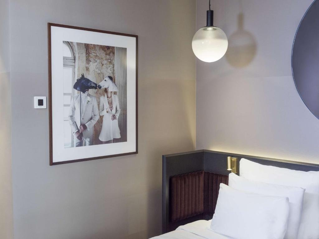 a bedroom with a picture on the wall next to a bed at Radisson Collection, Strand Hotel, Stockholm in Stockholm