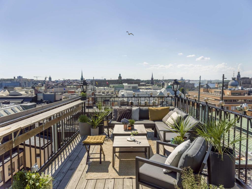 a balcony with furniture and a view of a city at Radisson Collection, Strand Hotel, Stockholm in Stockholm