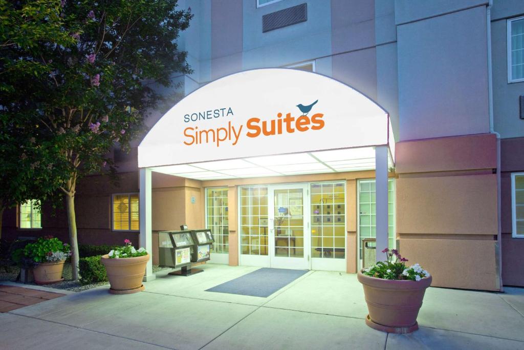 un cartello per una snykiss suite singole di fronte a un edificio di Sonesta Simply Suites Anaheim ad Anaheim
