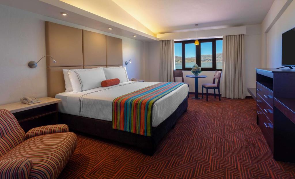 プーノにあるSonesta Posadas del Inca Punoのベッドとテレビが備わるホテルルームです。