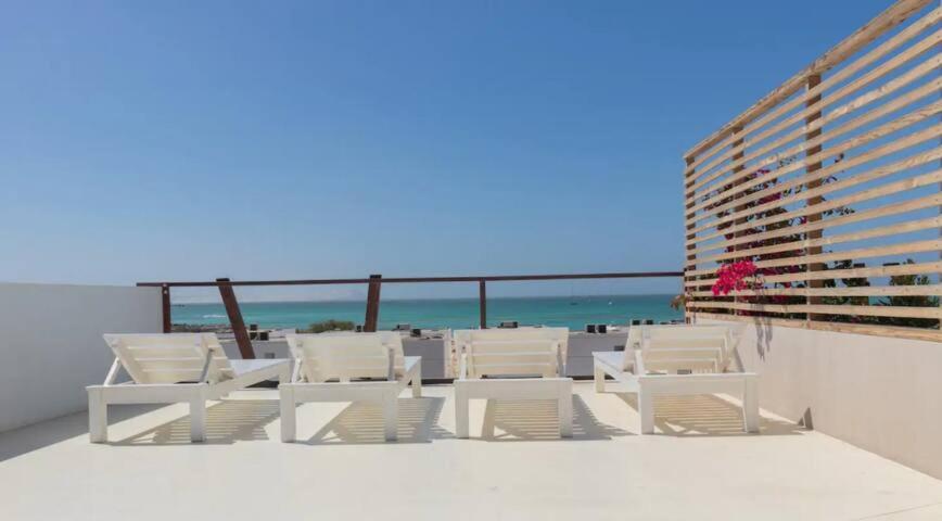 Un balcón con sillas blancas y vistas al océano. en Casa Meike, en Sal Rei