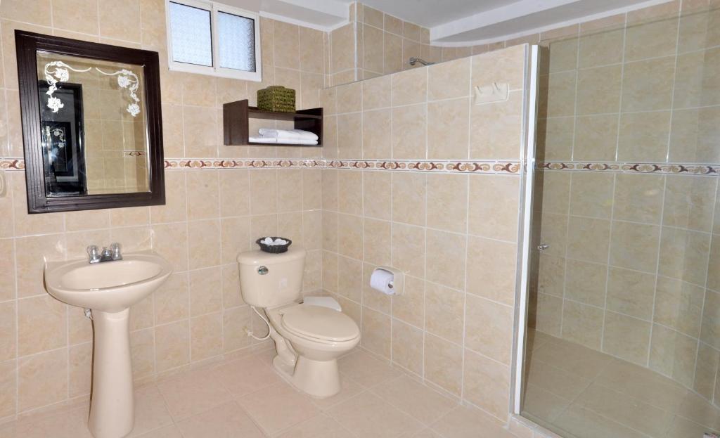 a bathroom with a toilet and a sink and a shower at Hotel Arawak Upar in Valledupar