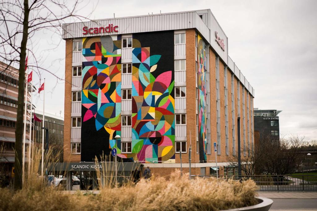 a large mural of a building with a clock on the side of it at Scandic Kista in Stockholm