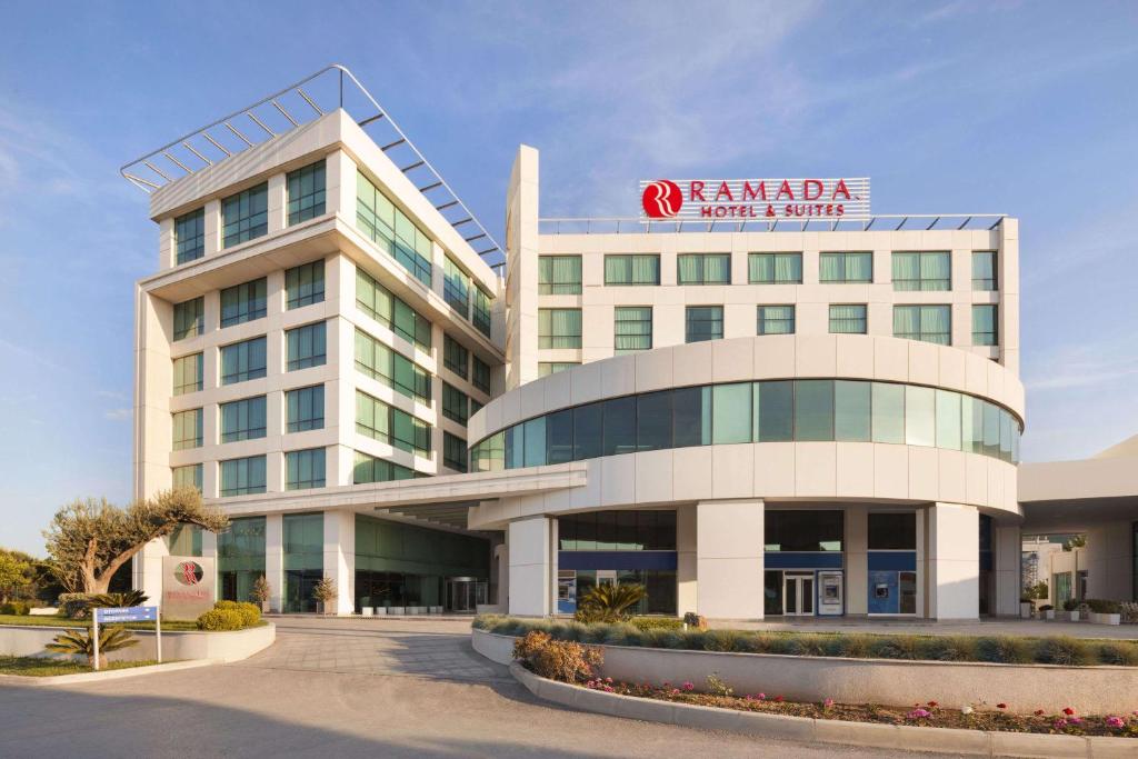 a large white building with a sign on it at Ramada Hotel & Suites by Wyndham Izmir Kemalpasa in Kemalpaşa