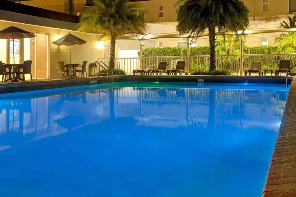 a large blue swimming pool in a hotel at Ramada by Wyndham Miami Springs/Miami International Airport in Miami