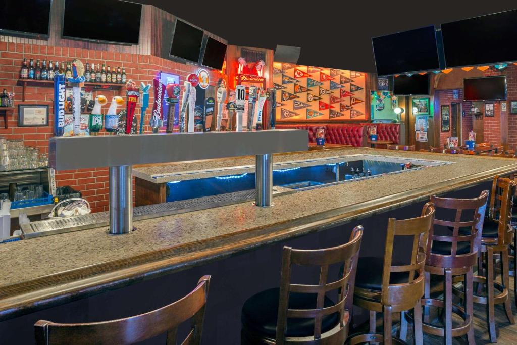 a bar with chairs at a bar at Ramada by Wyndham Miami Springs/Miami International Airport in Miami