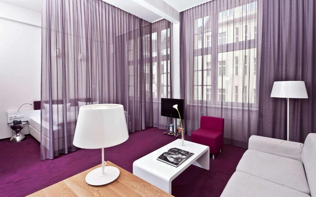 ein Wohnzimmer mit einer Couch und einem Sessel in der Unterkunft Wyndham Garden Berlin Mitte in Berlin
