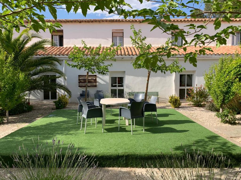 a garden with a table and chairs on grass at Ermita del Carmen Híjar in Híjar