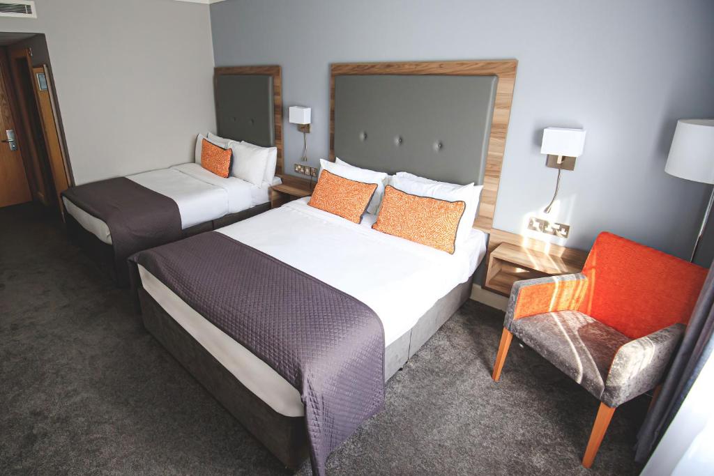 ein Hotelzimmer mit 2 Betten und einem Stuhl in der Unterkunft Westlodge Hotel & Leisure Centre in Bantry