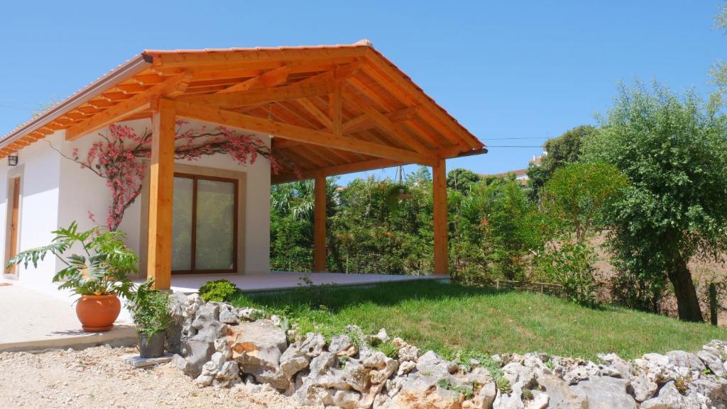 a view of a house with a wooden pergola at Casa Rosa, Quinta Carmo - Alcobaça/Nazaré in Alcobaça